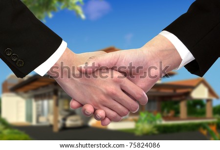 Businessman hand shake hands in front of new home