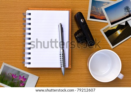 book , photo , pen, coffee cup and camera. On the floor of the wooden 