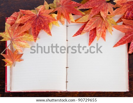 Open old book and Artificial  autumn  maple leafs