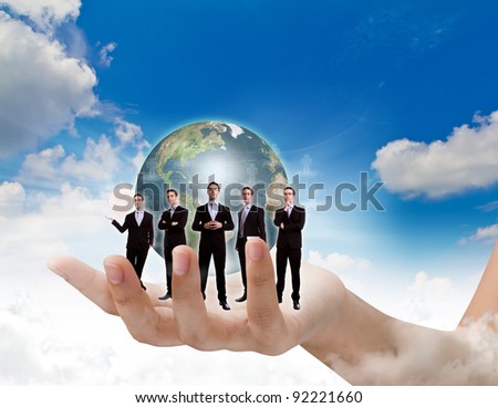 Young business man team in hand and earth over blue sky