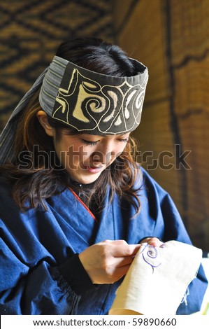 HOKKAIDO, JAPAN - NOVEMBER 17 :  Ainu Woman sewing in Shiraoi Ainu Museum on November 17,2009 in Hokkaido, Japan. Shiraoi Ainu Museum called Porotokotan, is one of Hokkaido\'s better Ainu Museums