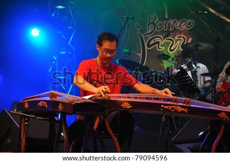 MIRI, SARAWAK, MALAYSIA - MAY 13 : Jason Lau (SIU2) play Zheng or Gu-Zheng (Chinese Music instrument) in Borneo Jazz Festival on May 13, 2011 in Miri Sarawak, Malaysia