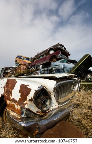 A pile of abandoned automobiles in a junk yard