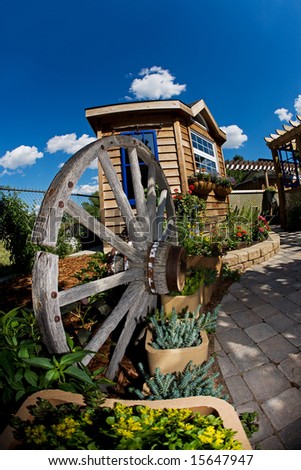 A beautiful backyard with shed and wagon wheel