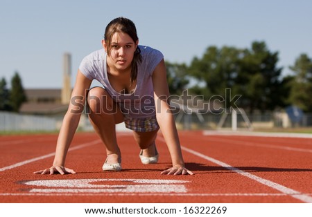 A pretty young woman exercising at a race track