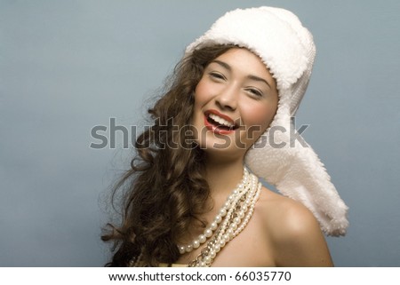 beautiful model with long hair and hat and pearls posing fashion in studio smiling