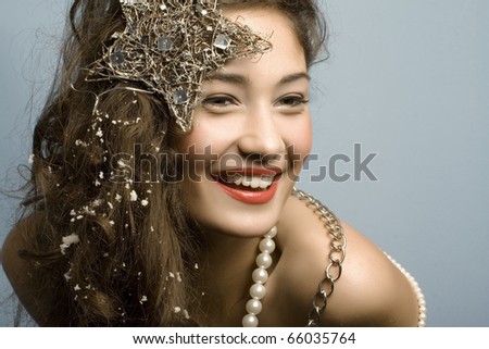 beautiful model with long hair and  star and pearls posing fashion in studio smiling