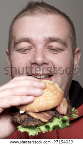Chubby man eating burger