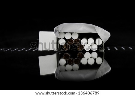 Close-up of cigarettes in pack and reflection. World No Tobacco Day.