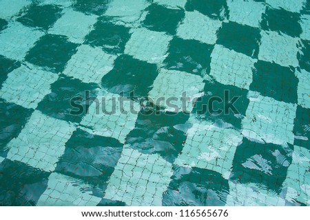 A pool with green ceramic tiles and water ripple effect use for background texture image