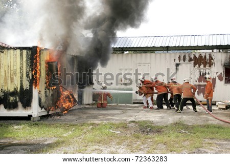 KUALA LUMPUR, MALAYSIA - FEB 23: Participants with the guidance from Fire and Rescue Department put out a fire during a Fire Awareness and Safety Day on February 23, 2011 in Kuala Lumpur, Malaysia