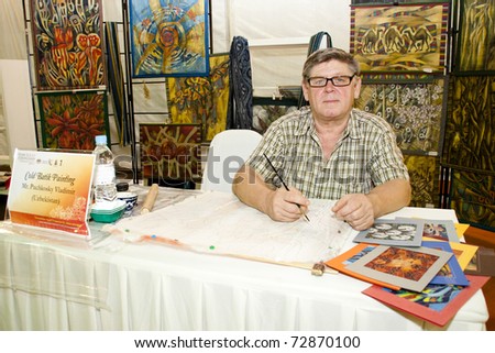 KUALA LUMPUR, MALAYSIA - MARCH 4: Puchkosky Vladimir, a traditional Cold Batik Painter, does a demonstration at the Malaysia National Craft Day 2011 on March 4, 2011 in Kuala Lumpur, Malaysia.