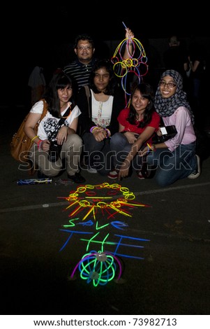 KUALA LUMPUR, MALAYSIA-MAR 26:Participants of Earth Hour Campaign pose with glow-in-the-dark decoration on Mar 26, 2011 in Kuala Lumpur.More than 4,000 cities in 131 countries celebrate Earth Hour
