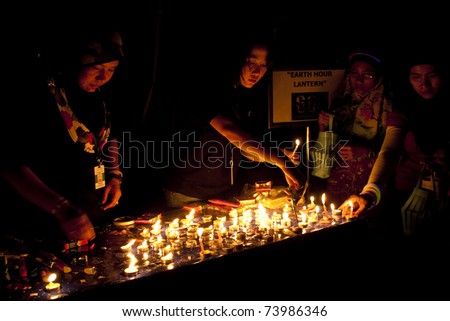 KUALA LUMPUR, MALAYSIA-MAR 26:Volunteer of Earth Hour Campaign distribute candle and lantern on Mar 26, 2011 in Kuala Lumpur. More than 4,000 cities in 131 countries celebrate Earth Hour