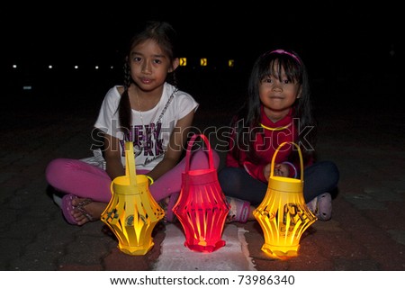 KUALA LUMPUR, MALAYSIA-MAR 26: Asirah, age 10, and Adriana, age 5 with lantern during Earth Hour Campaign on Mar 26, 2011 in Kuala Lumpur. More than 4,000 cities in 131 countries celebrate Earth Hour