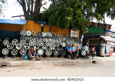 BANDUNG-JUNE 29:Unidentified man sells assorted steel alloy car rims June 29, 2011 in Bandung, Indonesia.Bandung economy is built on tourism and manufacturing and attracted investors worldwide.