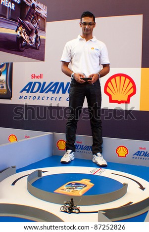 SEPANG, MALAYSIA - OCT 21: Unidentified Shell employee showcasing an interactive game for visitor of the Malaysian Motorcycle Grand Prix 2011 on October 21, 2011 at Sepang, Malaysia.