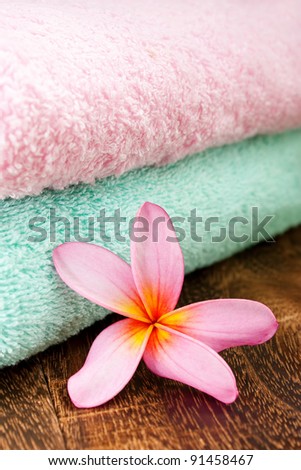 Clean Fresh Towel with Tropical Plumeria for spa and wellness concept focus pointed at the Tropical Plumeria using rule of third (RO3) and shallow DOF