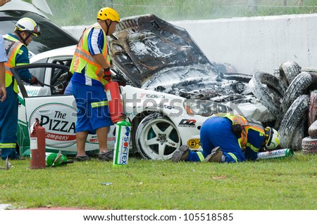 PATTAYA - JUNE 17: Rescue workers extinguish a fire in a wrecked Honda Integra during a touring car race at Bira Circuit, Pattaya, Thailand on June 17, 2012.