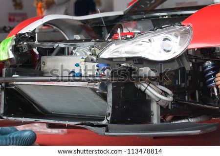 Disassembled front of racing car with radiator visible. Shallow depth of field.