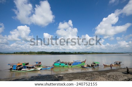 Lay Myo River, Rakhin State, Myanmar - October 17, 2014: Vessels unloading gravel and rocks for road construction that has been found further upstream.