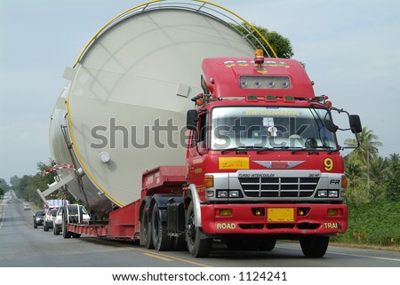 Red truck hauling a large tank