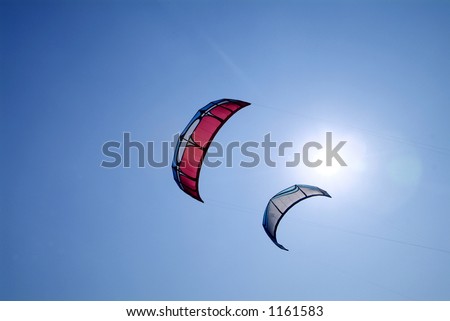 Two kite surfer kites and the sun