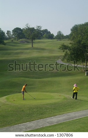 Lady golf player teeing off on at an uphill par five