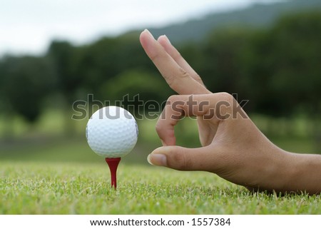 Hand and golf ball on tee