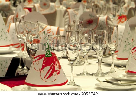 Tables prepared for a party in the ballroom of a luxury hotel. Bibs and hats decorated with crayfish.