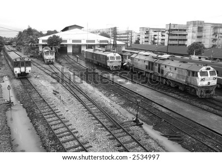 Trains at the railway station of Had Yai in the south of Thailand on a rainy day. Black and white photo.