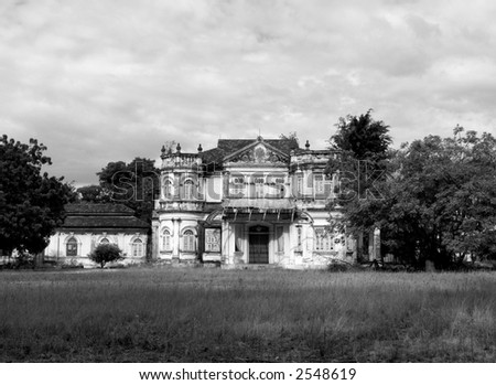 19th century mansion in a big garden, falling apart. Black and white photography.