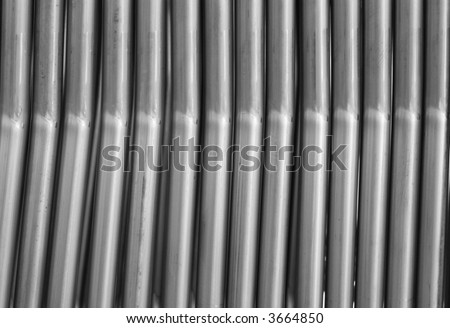 Parallel steel tubes, components at a furniture factrory. Black and white photo.