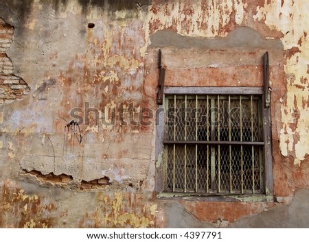 Window with steel bars of old brick building, lacking maintenance