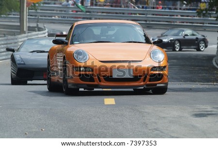 Orange, German sports car at a race track
