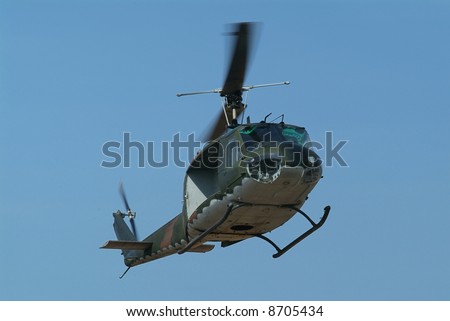 Military helicopter with camouflage paint hovering