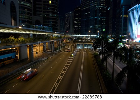 Street scene from Hong Kong island shot at night. Long exposure makes moving cars and people blurry.