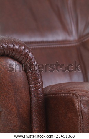 Detail of brown leather, luxury recliner made from cowhide. Shallow depth of field with the background out of focus.