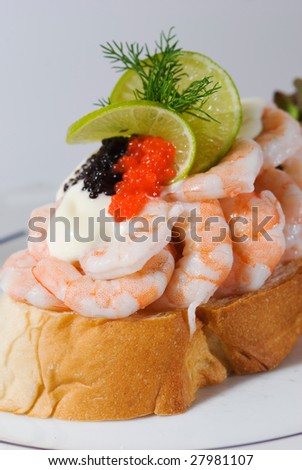 Seafood sandwich with shrimps, roe of capelin, mayonnaise, lime and dill on a white plate.