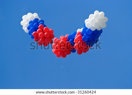 Red, white and blue balloons on a blue sky background
