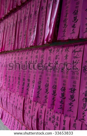 Prayer flags or prayer slips, black Chinese characters on pink tissue paper, at Chua Thien Hau Temple in Cho Lon, Ho Chi Minh Sity, Vietnam.