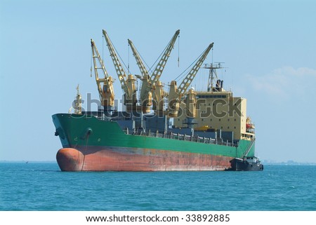 Empty bulk ship at anchor in tropical waters