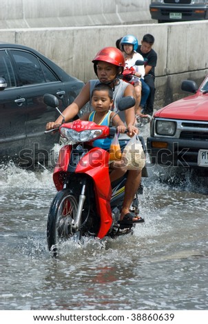 BANGKOK - AUGUST 14: Cars, trucks and motorcycles navigating through the flood after the heaviest monsoon rain in 20 years in the capital on August 14, 2009 in Bangkok, Thailand.