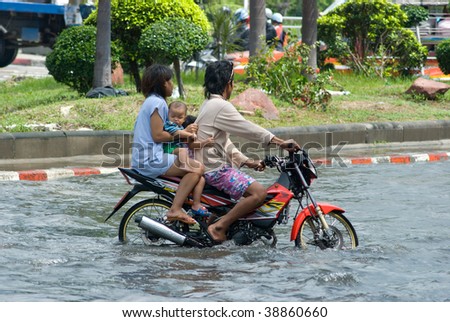 BANGKOK - AUGUST 14: Family on a motorbike navigating through the flood after the heaviest monsoon rain in 20 years in the capital on August 14, 2009 in Bangkok, Thailand.