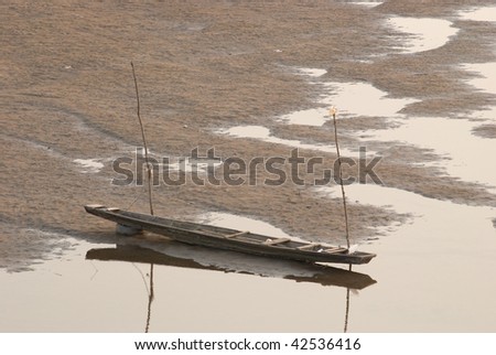 Traditional, wooden boat on the dry riverbed of Mekong river near Vientiane, Laos.