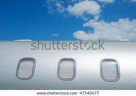 Detail of gray metallic corporate jet with windows closed by blinds.