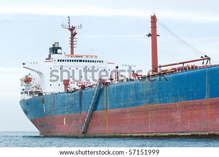 Rusty, old oil tanker moored in calm waters