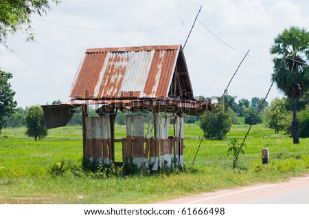 Primitive bus stop shelter in rural Nakhon Ratchasima, Thailand. Rice fields in the background.