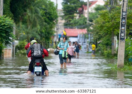 AYUTTAYA - OCTOBER 20: People and a motorbike on a narrow road during unusually heavy monsoon flooding on October 20, 2010 in Ayuttaya, Thailand.