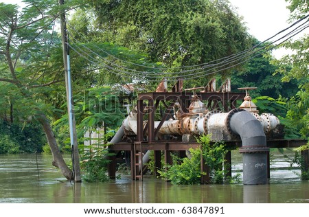Pump station next to a river that is overflowing. Photo taken in Nakhon Ratchasima in Thailand.